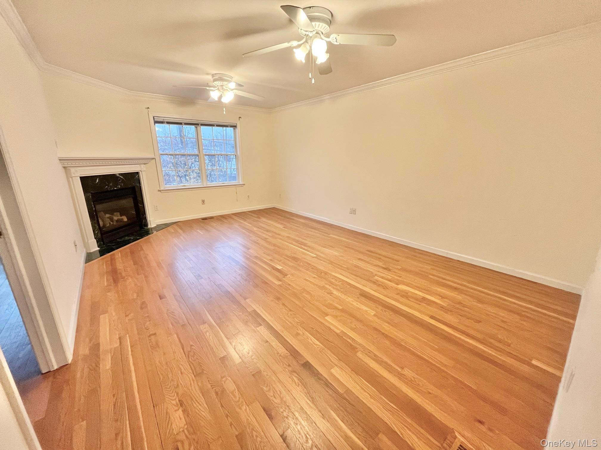 153 Montgomery Avenue, Unit B Scarsdale, NY 10583 - Photo 3 of 14 an empty room with wooden floor fan and windows