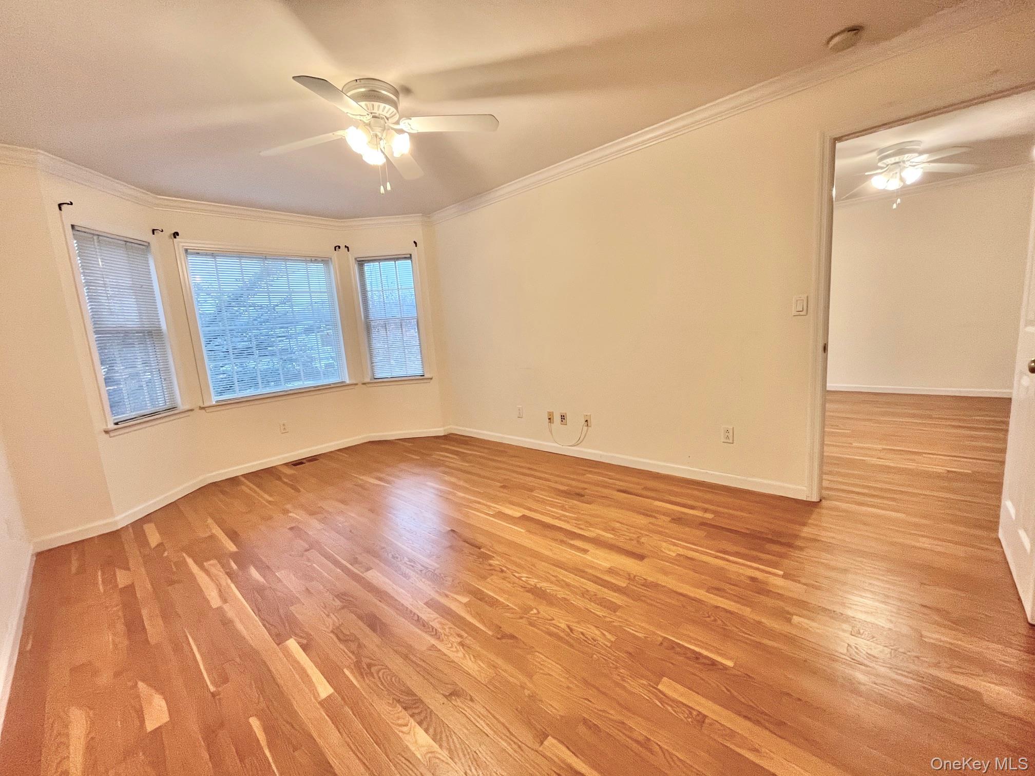 153 Montgomery Avenue, Unit B Scarsdale, NY 10583 - Photo 4 of 14 a view of an empty room with wooden floor and a ceiling fan