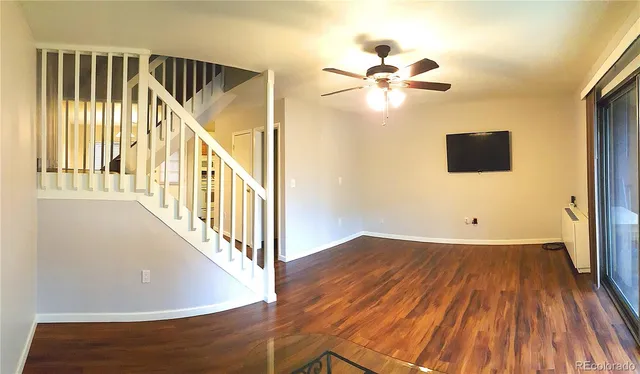 a view of a hallway with wooden floor and staircase
