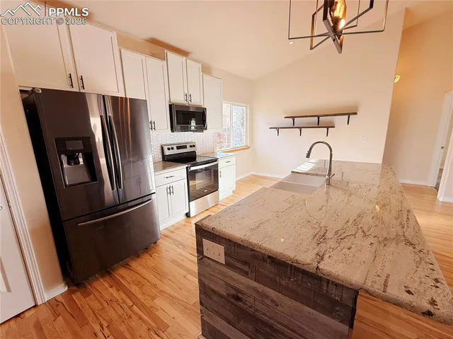 a kitchen with granite countertop a sink stove and refrigerator
