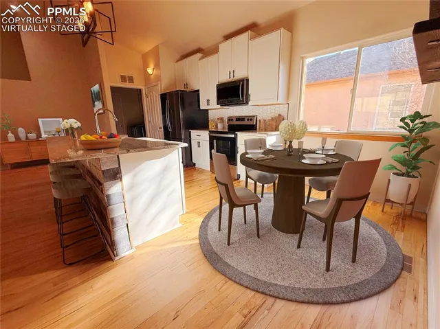 a large kitchen with stainless steel appliances wooden floors and wooden cabinets