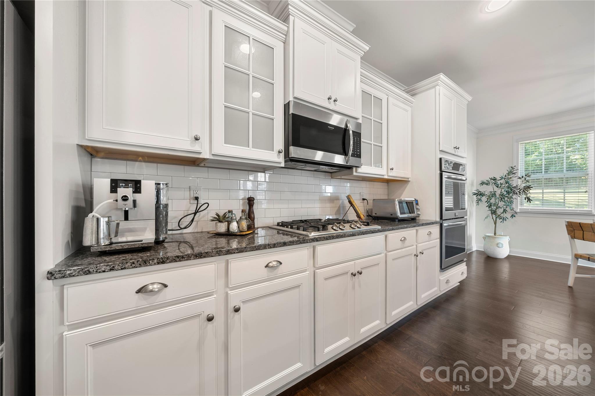 11266 Trailside Road Concord, NC 28027 - Photo 13 of 48 a kitchen with granite countertop white cabinets stainless steel appliances and sink