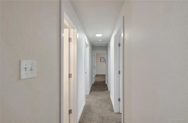 a view of a hallway with wooden shelves
