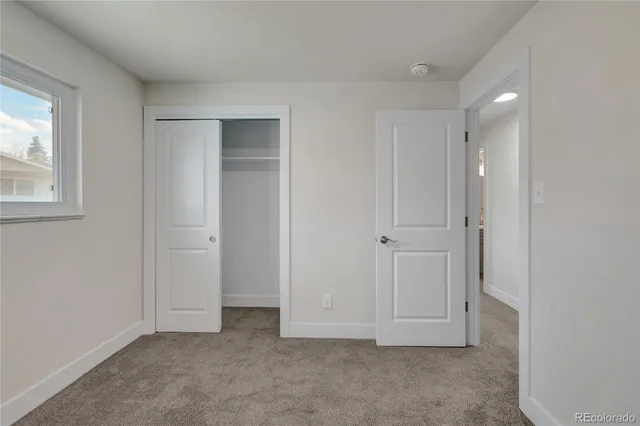 an empty room with windows and closet
