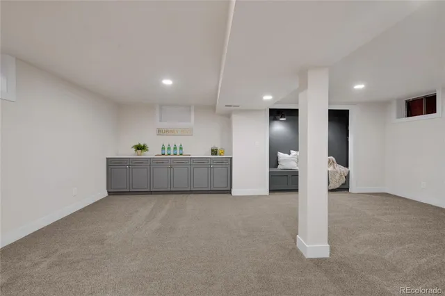 a view of an empty room with kitchen and a window