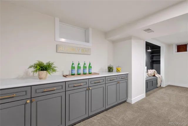 a white kitchen with cabinets and wooden floor