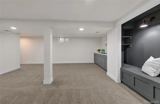 a view of an empty room and kitchen with furniture