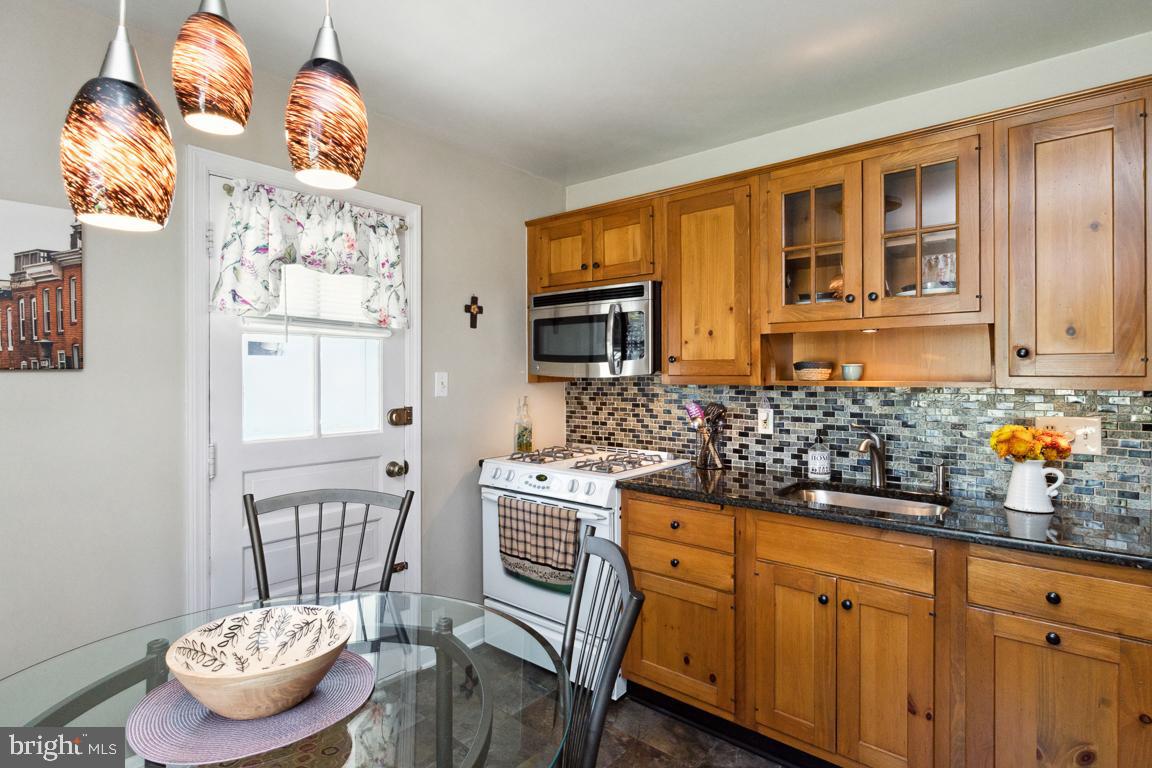 2903 Church Road Parkville, MD 21234 - Photo 8 of 37 a kitchen with stainless steel appliances granite countertop a stove and a wooden cabinets