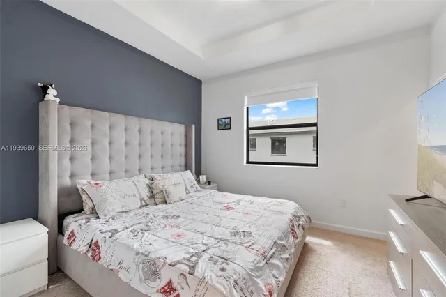 a bedroom with a bed and a painting on the wall