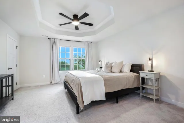 a spacious bedroom with a bed and a ceiling fan