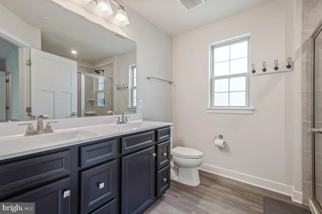 a bathroom with a double vanity sink a toilet and a window