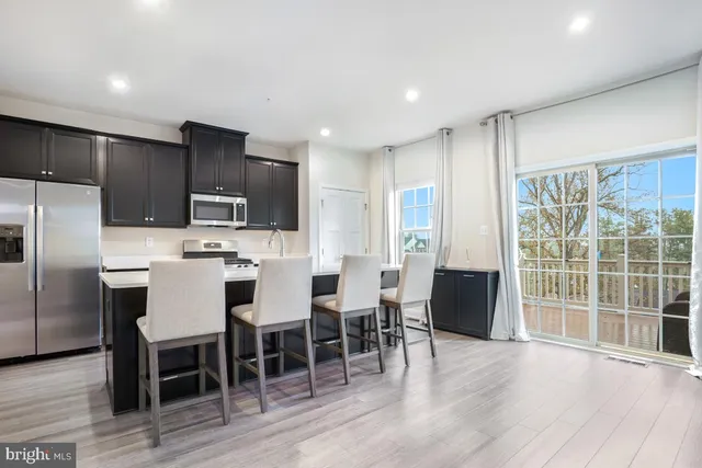 a large kitchen with a table chairs refrigerator and cabinets