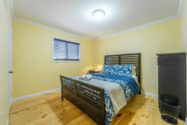 a bedroom with a bed and wooden floor
