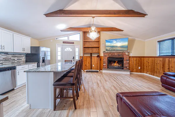 a dining room with wooden floor a chandelier a wooden table and chairs