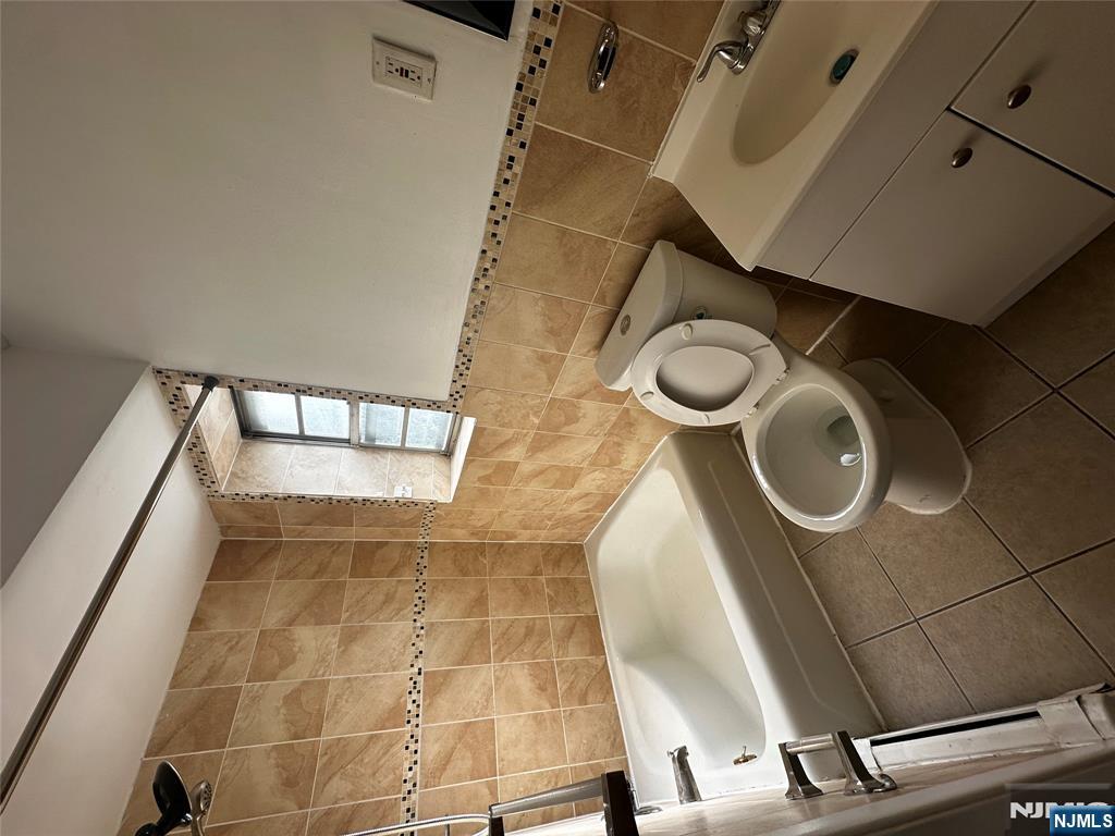 218 Cliff Street, Unit 1 Cliffside Park, NJ 07010 - Photo 7 of 7 a bathroom with a sink mirror vanity and toilet