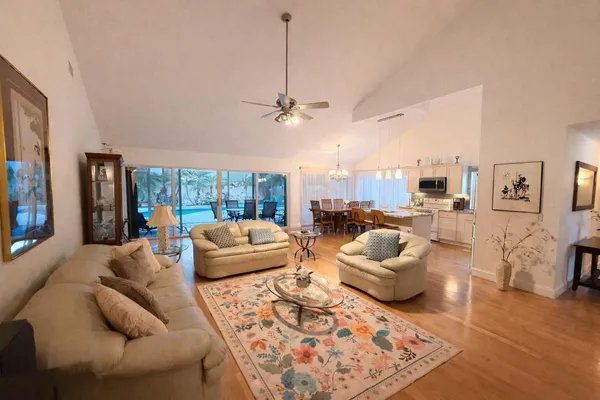 a living room with furniture a chandelier and a flat screen tv