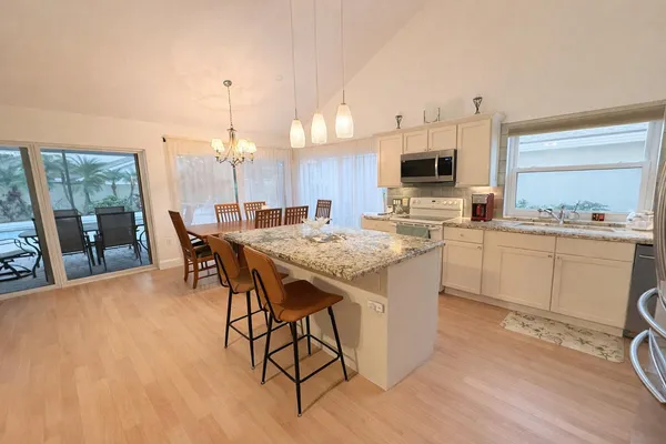 a kitchen with a table chairs sink and cabinets