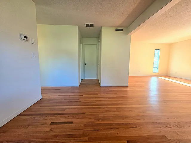a view of empty room with wooden floor