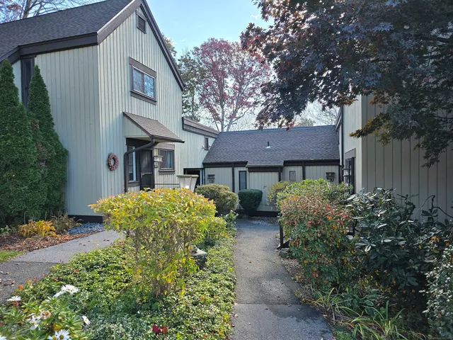 a view of a house with brick walls and a tree