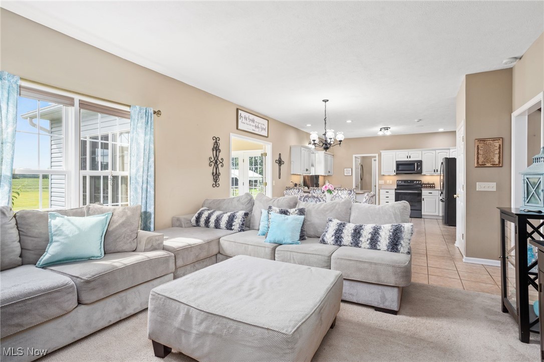 11620 Friendsville Road Creston, OH 44217 - Photo 11 of 40 Living room featuring a chandelier, light colored carpet, and light tile patterned floors
