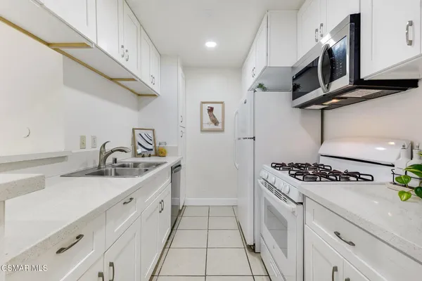 a kitchen with stainless steel appliances granite countertop a sink stove and cabinets