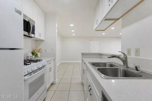 a kitchen with a sink and stove top oven