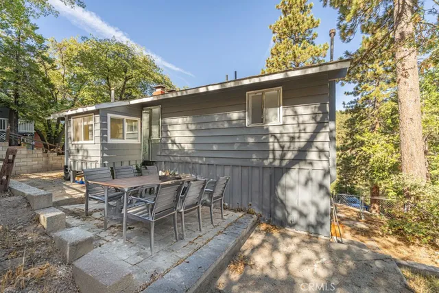 a patio with table and chairs and potted plants