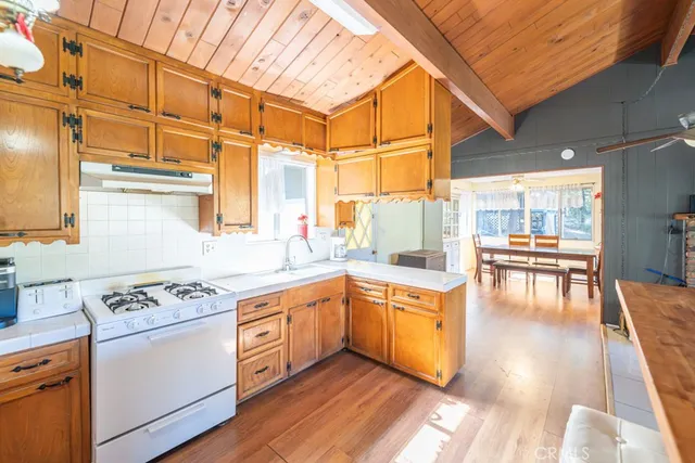 a kitchen with stainless steel appliances granite countertop a stove and white cabinets with wooden floor