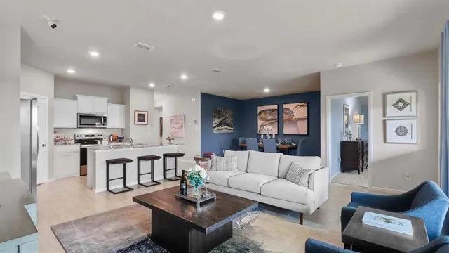 a kitchen with kitchen island a sink a stove a refrigerator cabinets and dining table