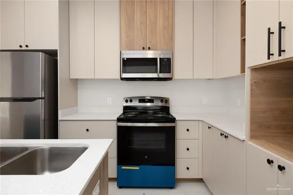a kitchen with granite countertop white cabinets and stainless steel appliances