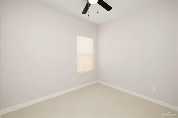 an empty room with a window and a ceiling fan