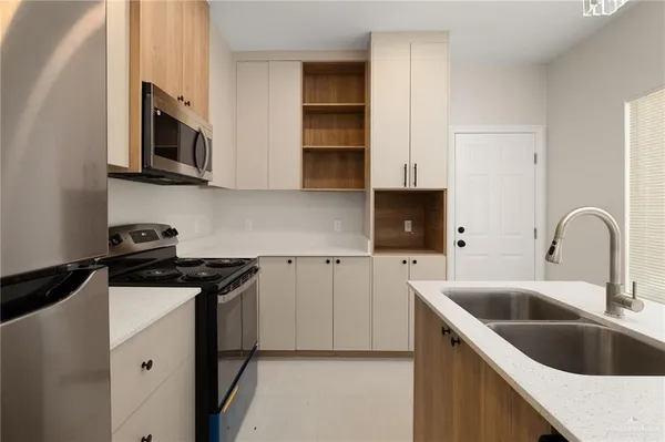 a kitchen with stainless steel appliances granite countertop a sink and a stove