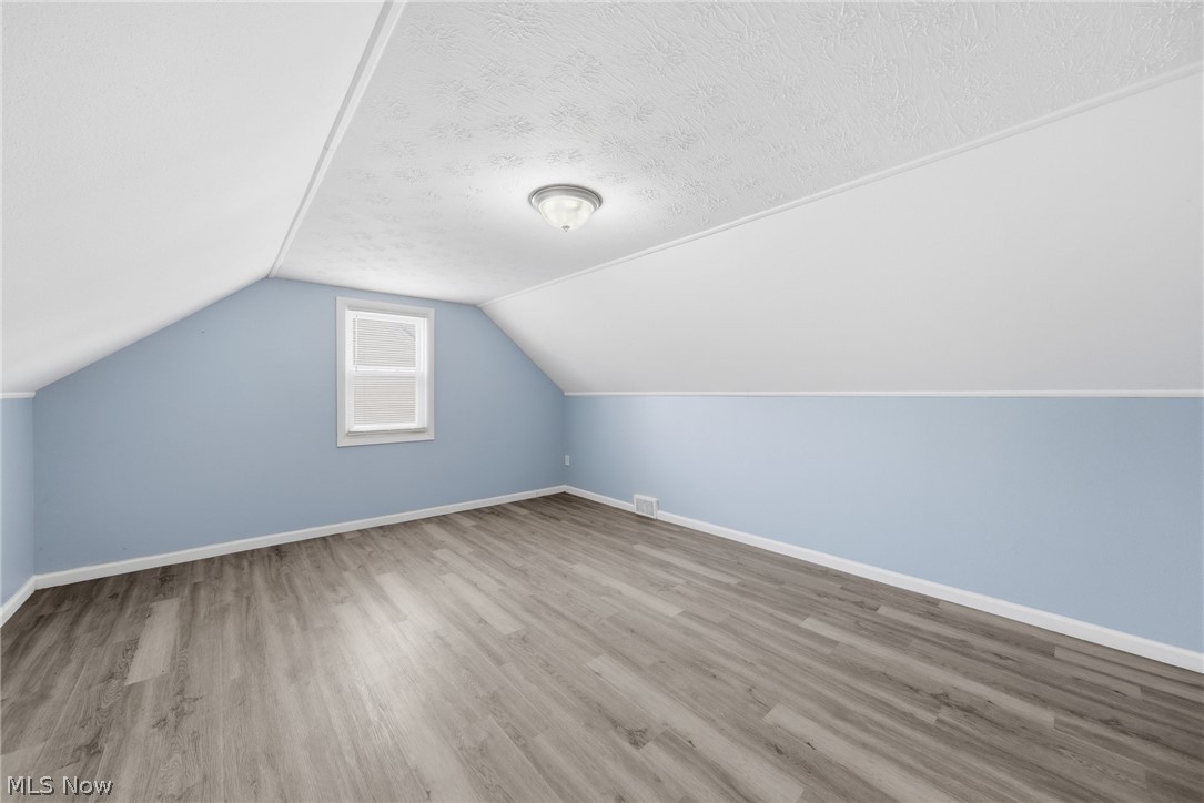 20705 Hansen Road Maple Heights, OH 44137 - Photo 18 of 24 Additional living space with wood finished floors and a textured ceiling