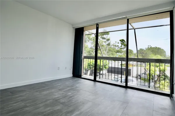 a view of an empty room with wooden floor and doors