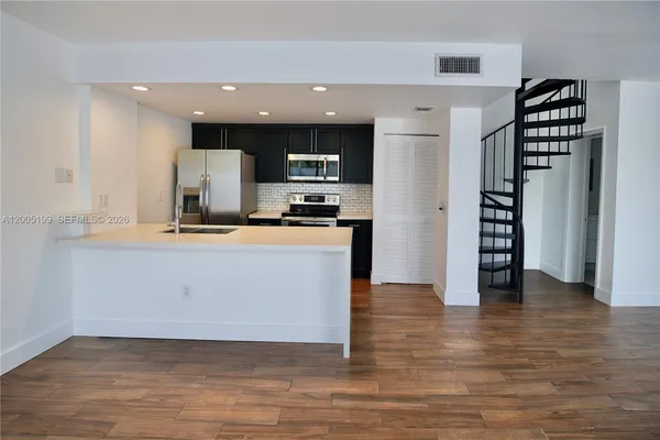 a kitchen with stainless steel appliances a refrigerator and a stove top oven