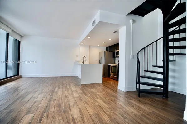 a view of a kitchen with wooden floor and electronic appliances