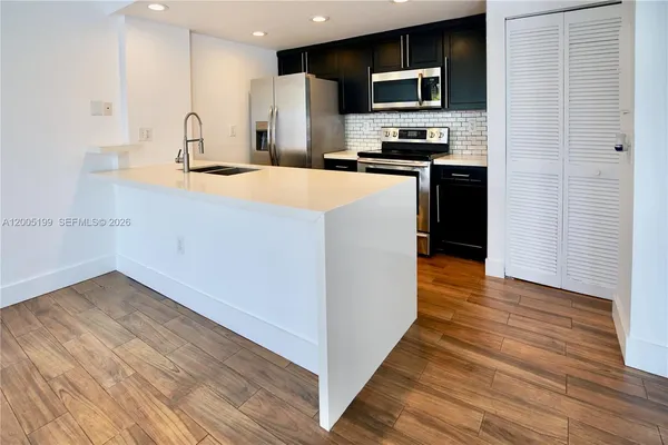 a kitchen with stainless steel appliances a refrigerator stove and microwave