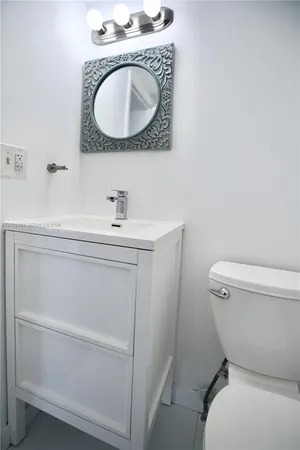 a bathroom with a sink a toilet and a mirror