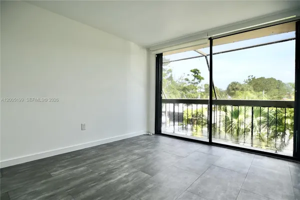 an empty room with wooden floor and large windows