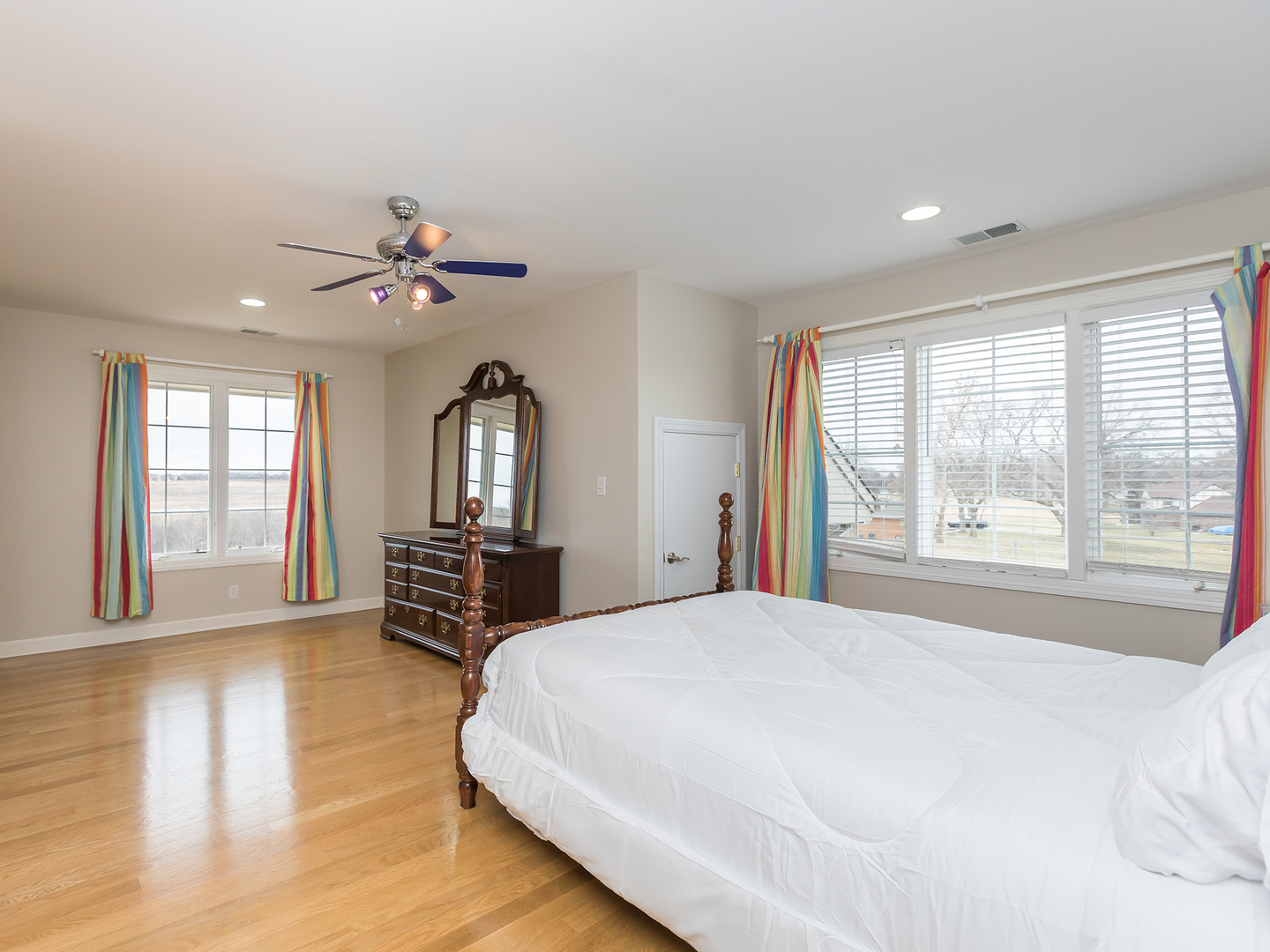 3N480 Fair Oaks Road West Chicago, IL 60185 - Photo 18 of 25 a spacious bedroom with a large bed a chandelier and windows