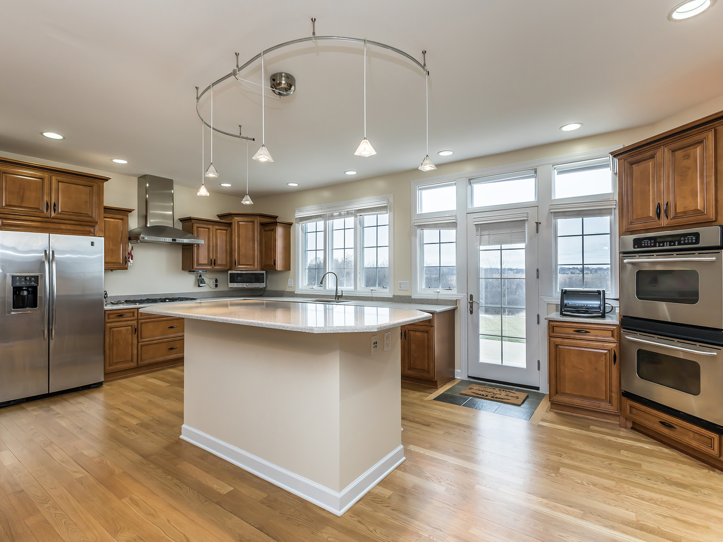 3N480 Fair Oaks Road West Chicago, IL 60185 - Photo 7 of 25 a kitchen with stainless steel appliances granite countertop a refrigerator a sink dishwasher a oven and a dining table with wooden floor