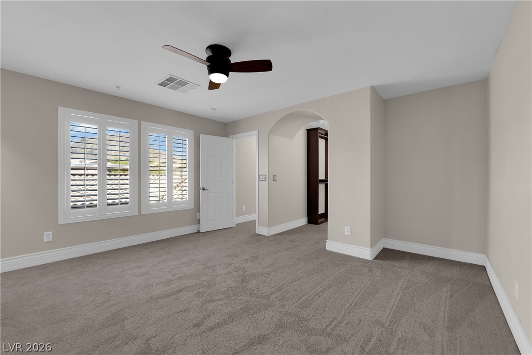 646 Monument Point Street Henderson, NV 89002 - Photo 23 of 44 A quiet retreat with plush carpeting, offering serene outdoor views through classic louvered shutters.