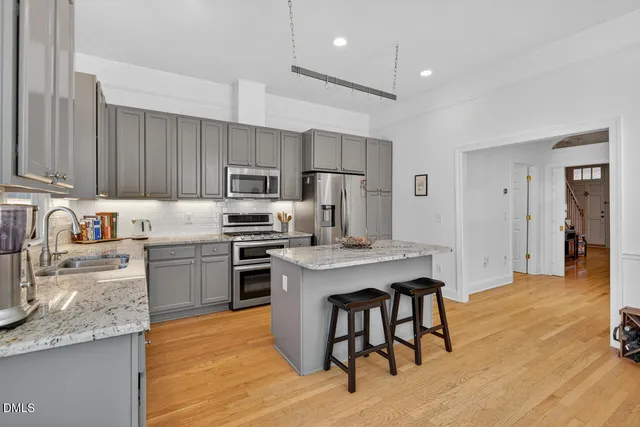 a kitchen with kitchen island a sink stainless steel appliances and cabinets