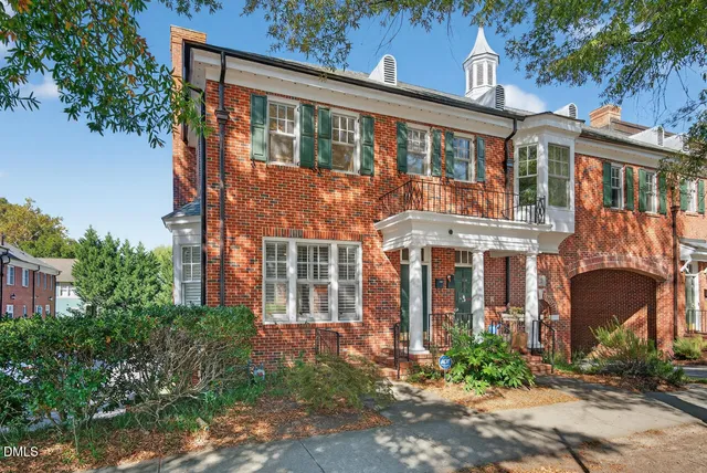 front view of a brick house with a yard