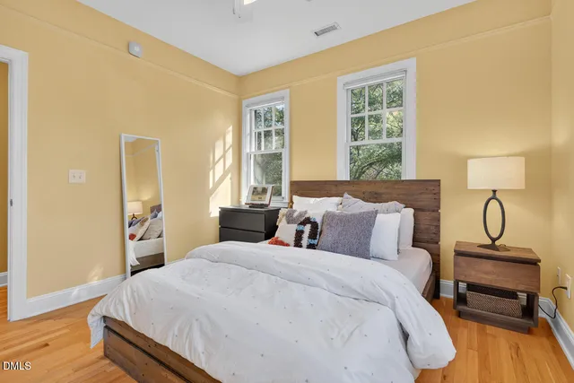 a bedroom with a bed and wooden floor