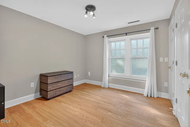 a view of empty room with wooden floor