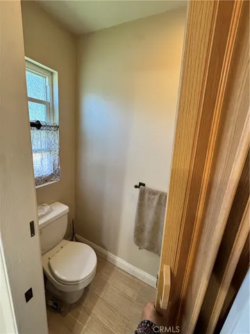 a white toilet sitting next to a small window