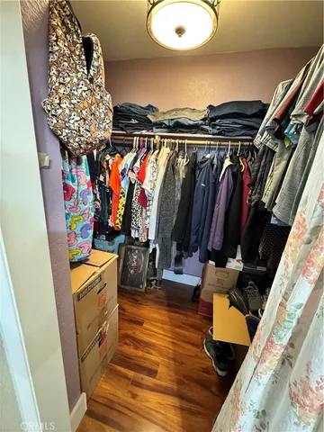 a view of walk in closet with clothes and shoes