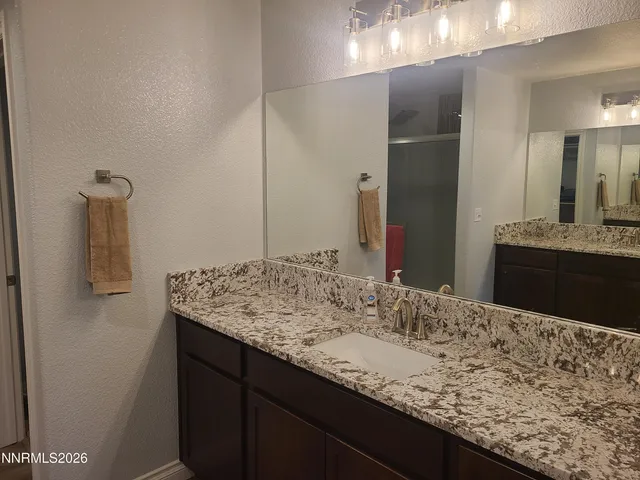 a bathroom with a granite countertop sink and a mirror