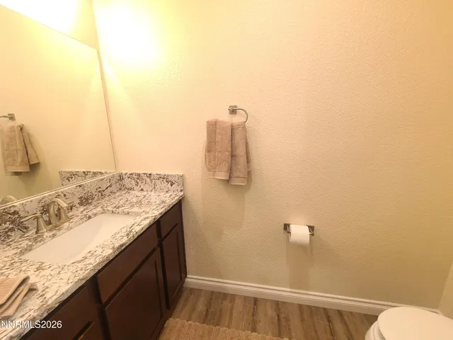 a bathroom with a granite countertop sink and toilet